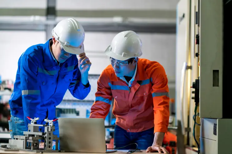 two men with a laptop in the manufacture